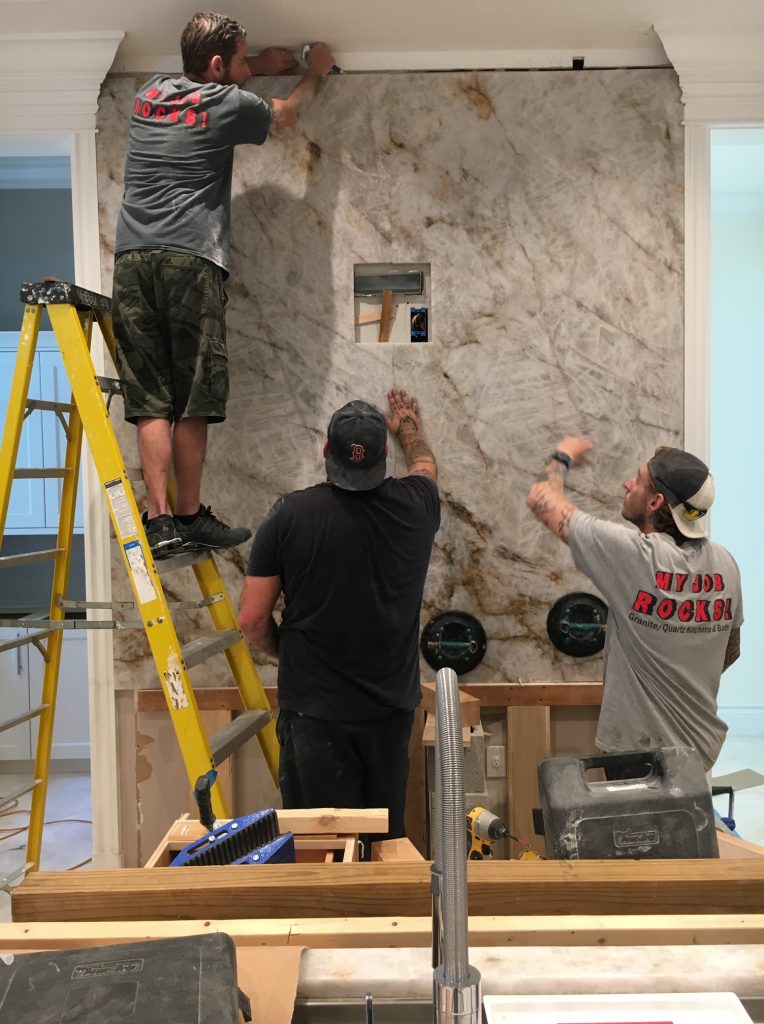 men installing granite backsplash